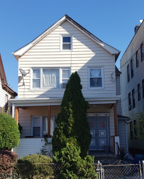 a front view of a house with plants and entryway