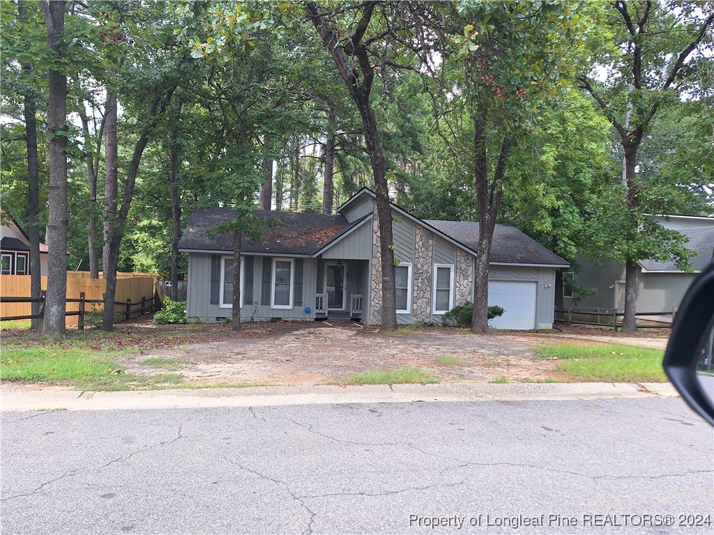 a view of a house with a yard and large tree