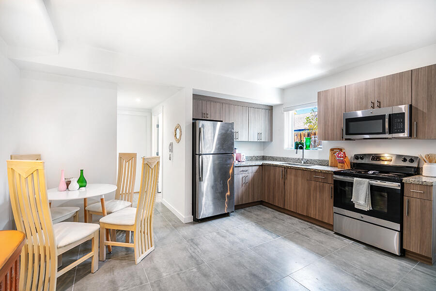 a kitchen with a refrigerator and a stove top oven