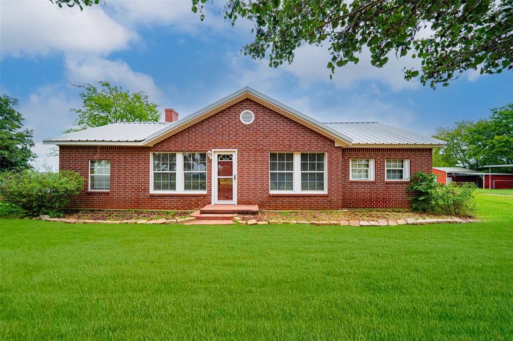 a front view of a house with a garden and trees