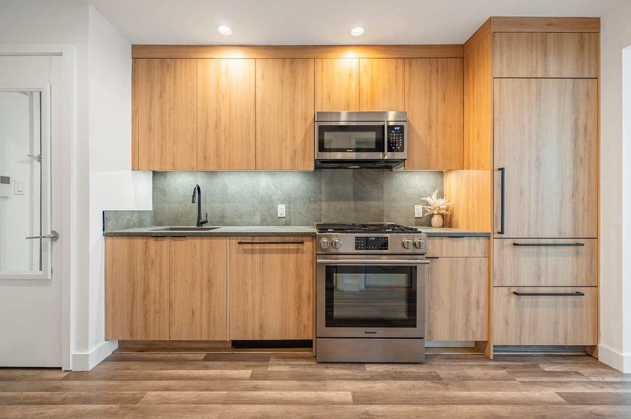 a kitchen with stainless steel appliances a stove a microwave and a sink