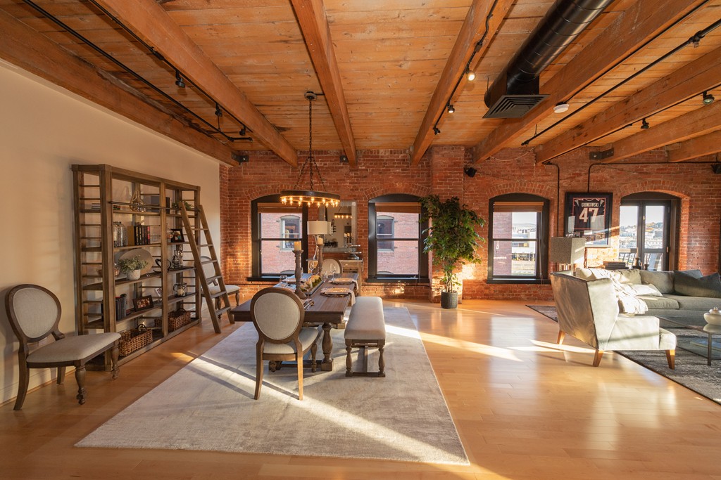 a living room with furniture a chandelier and large windows