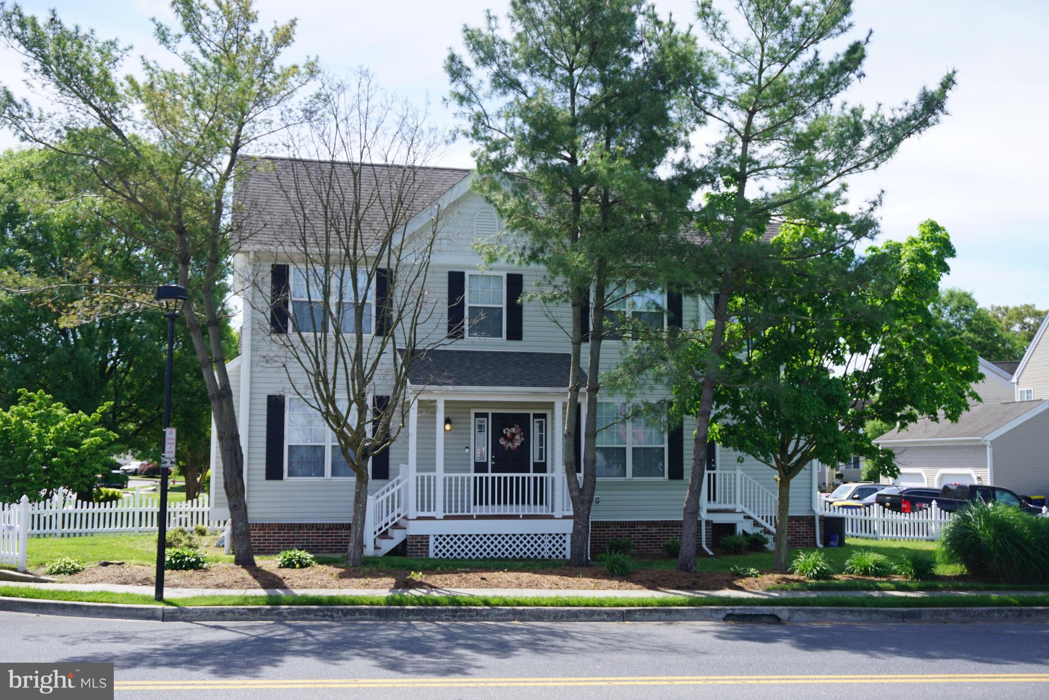 a front view of a house with swimming pool and trees