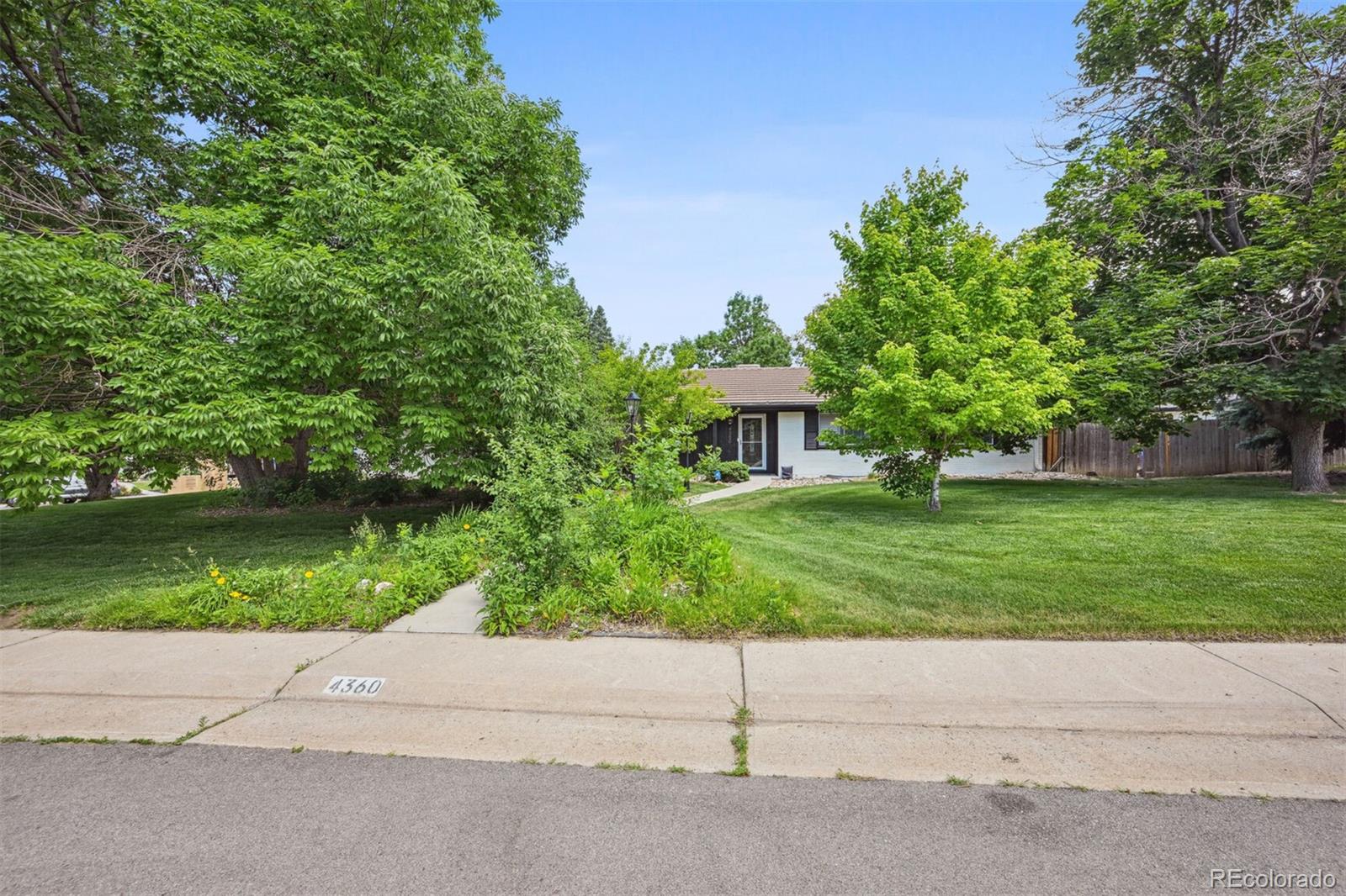 a front view of a house with a garden and yard