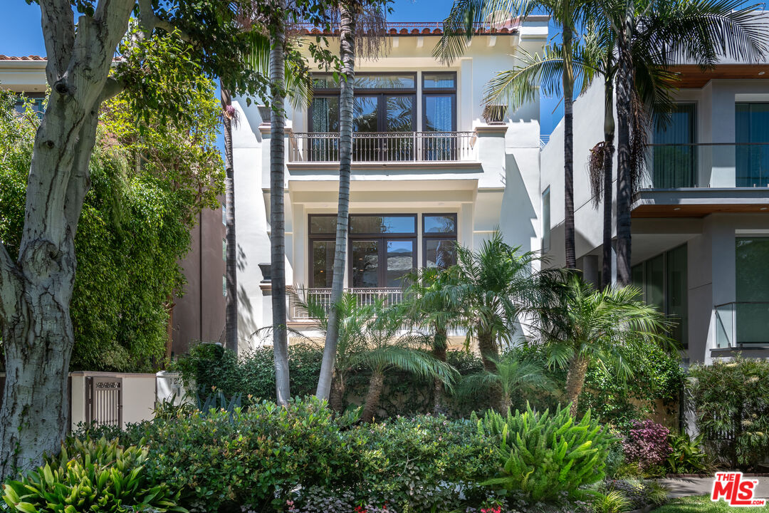 front view of house with a yard and potted plants