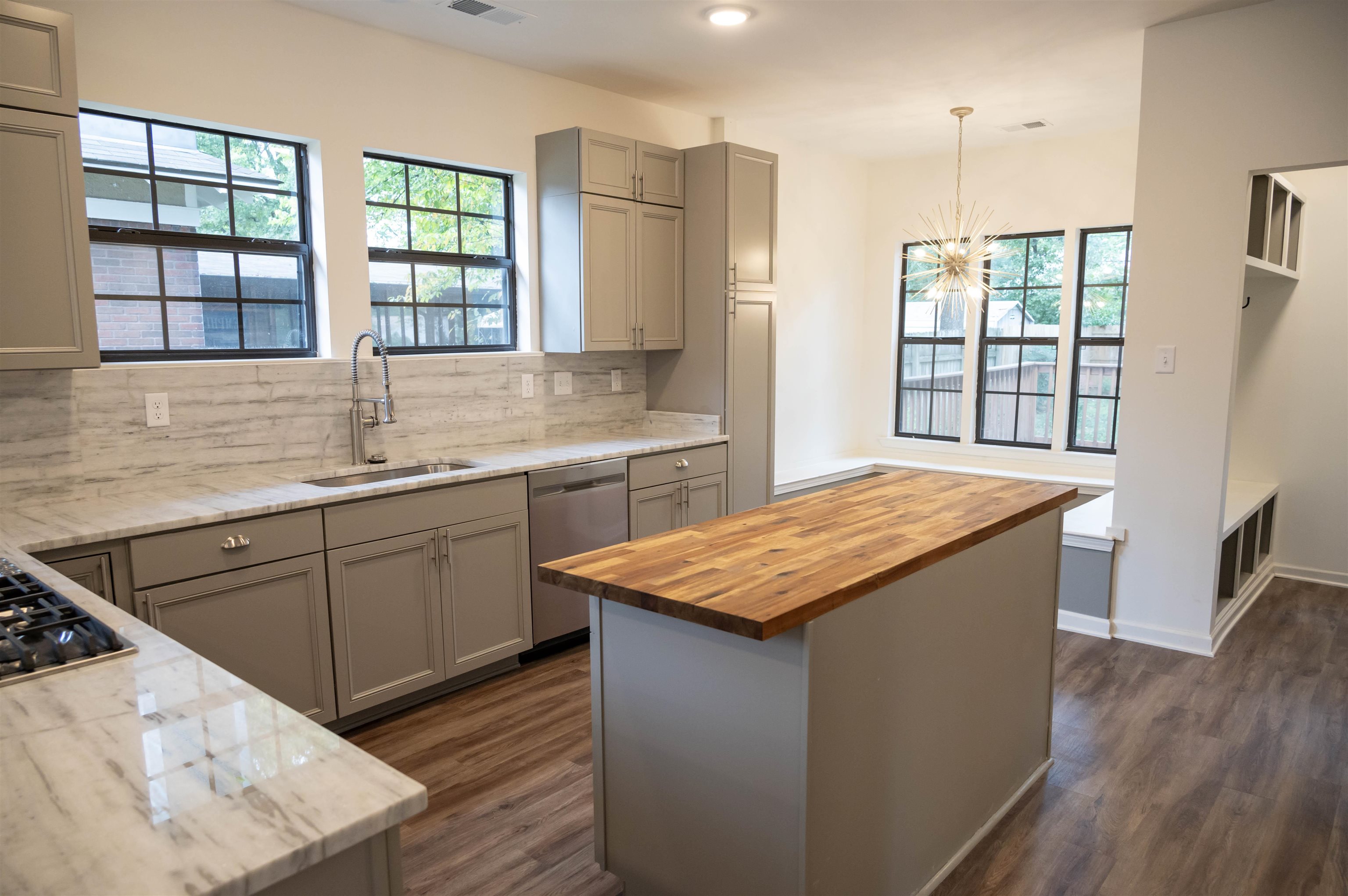 a kitchen with stainless steel appliances granite countertop wooden cabinets sink and window