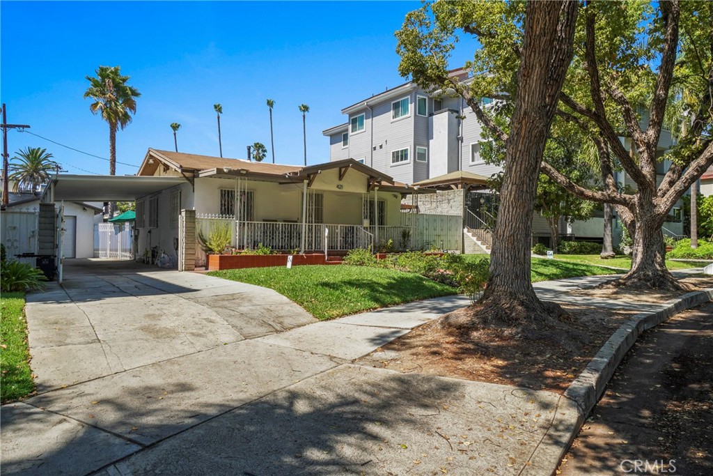 a front view of a house with a yard and potted plants