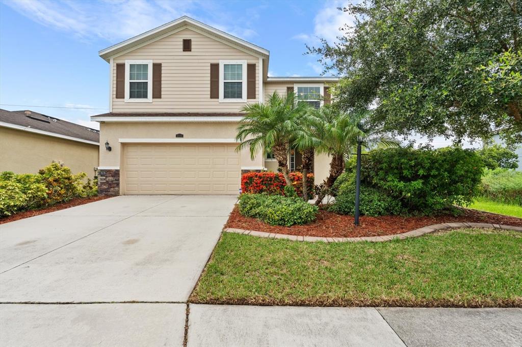 a front view of a house with a yard and garage