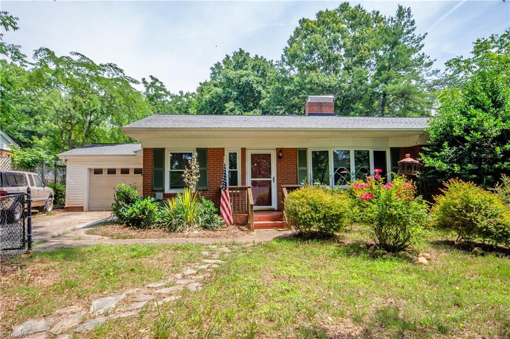 Brick ranch with hardwoods, fireplace, large kitchen/dining area, built-ins, sitting on a private city lot!