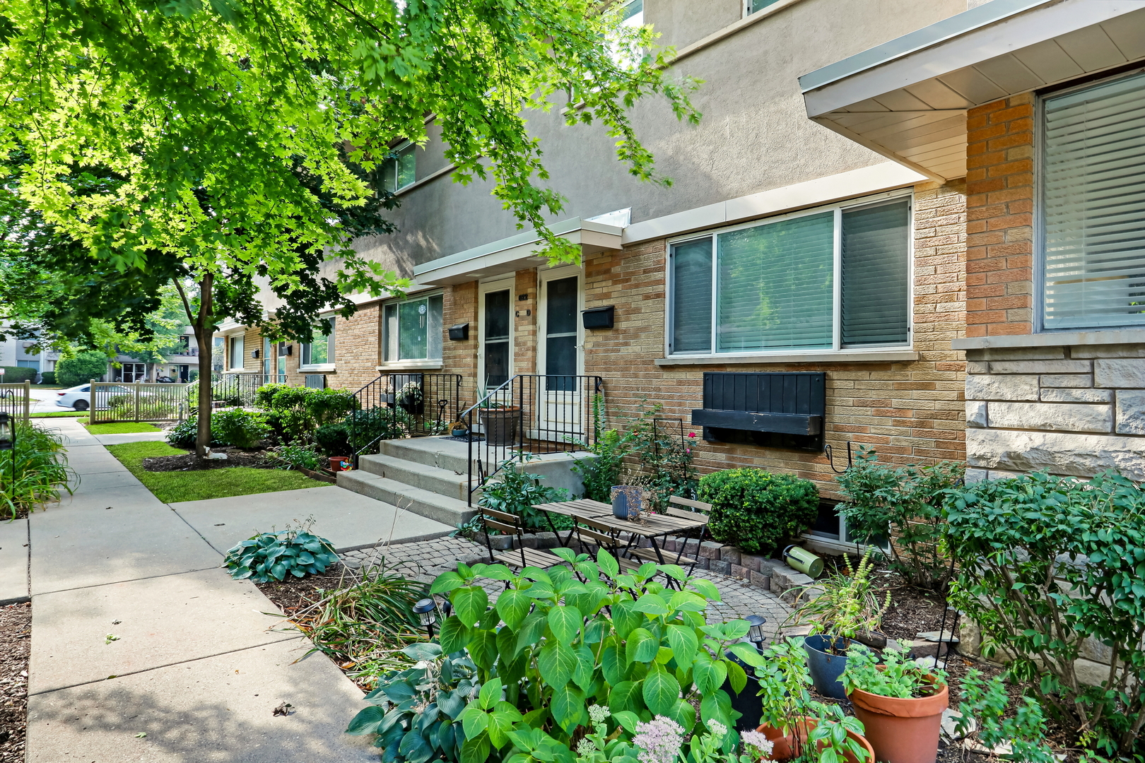 a front view of a house with a yard and potted plants