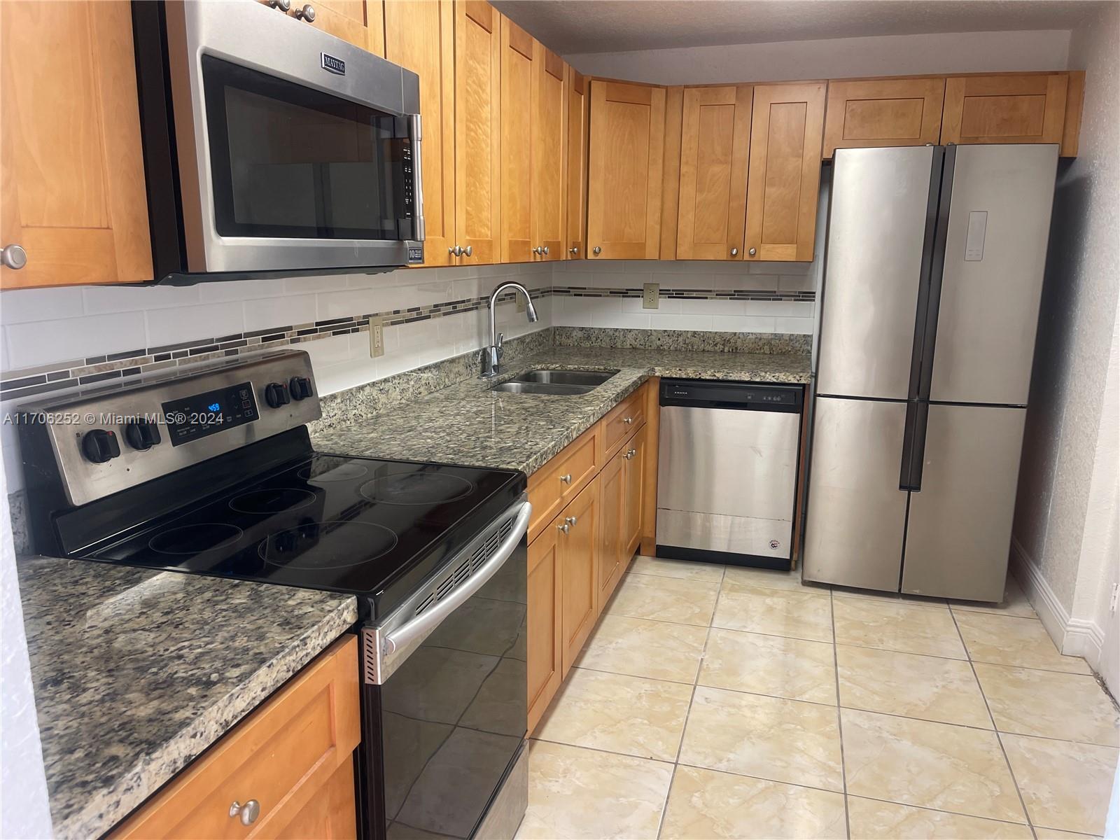 a kitchen with a stove a sink and a refrigerator