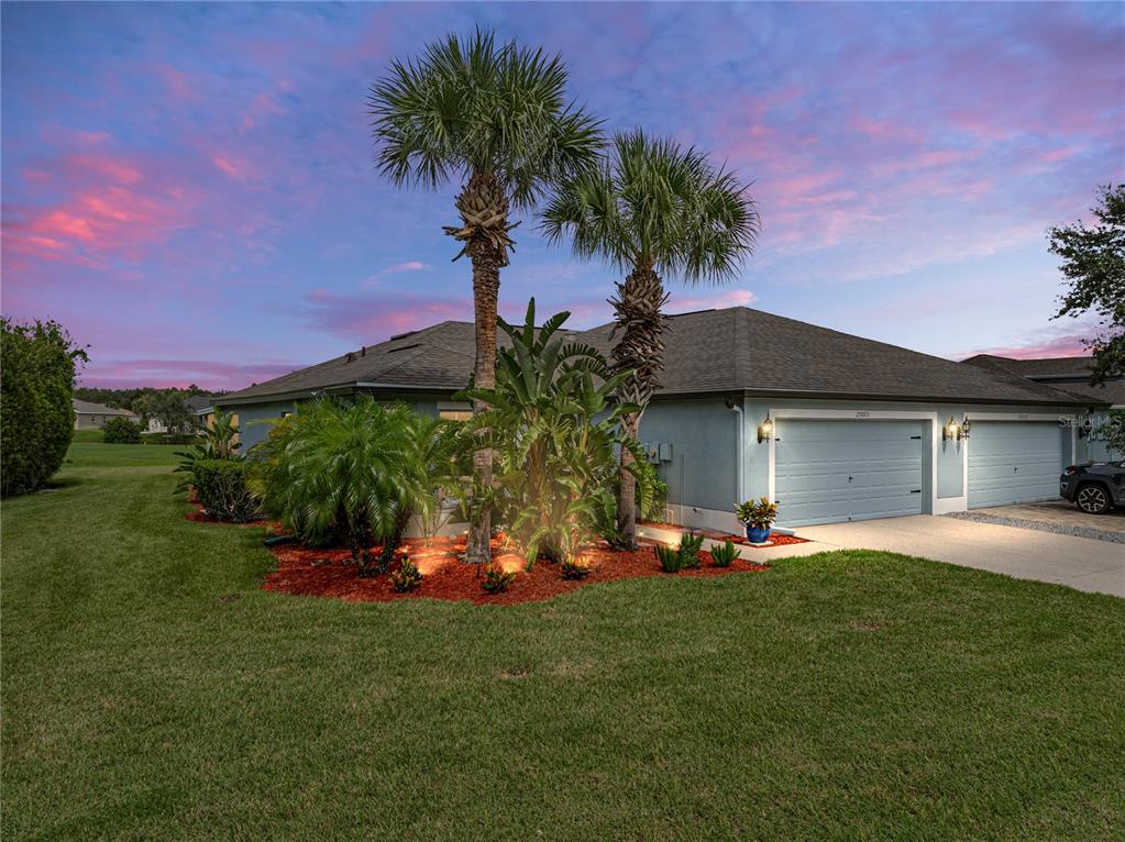 a front view of a house with a yard and trees