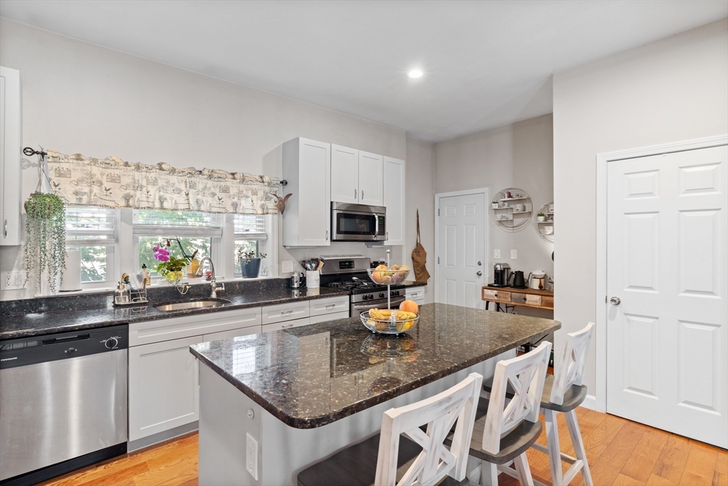 a kitchen with stainless steel appliances granite countertop a sink a stove and a refrigerator