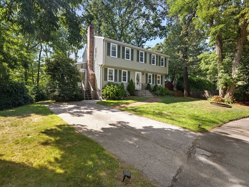 a front view of a house with a yard and trees