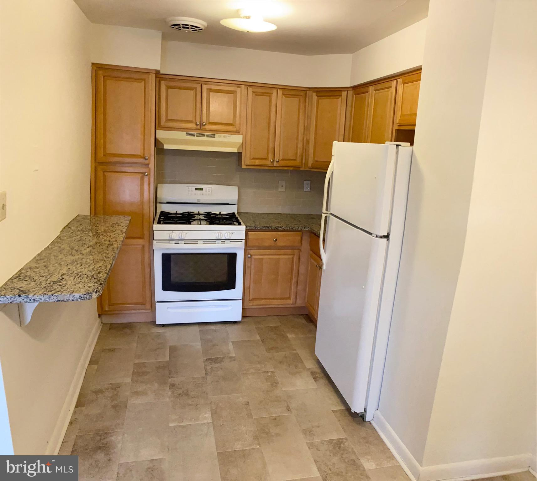 a kitchen with a stove a refrigerator and a sink