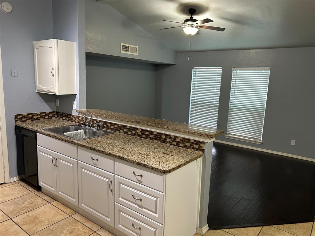 a kitchen with granite countertop a sink stainless steel appliances and cabinets