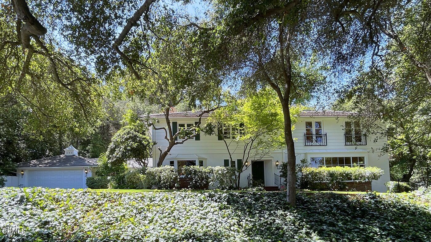 a front view of a house with a garden