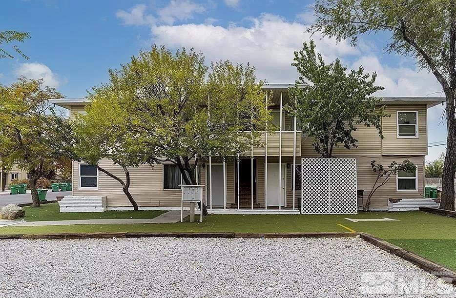 a front view of a house with a yard and trees