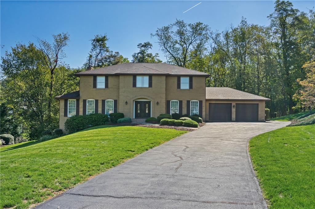 a front view of a house with a yard and trees