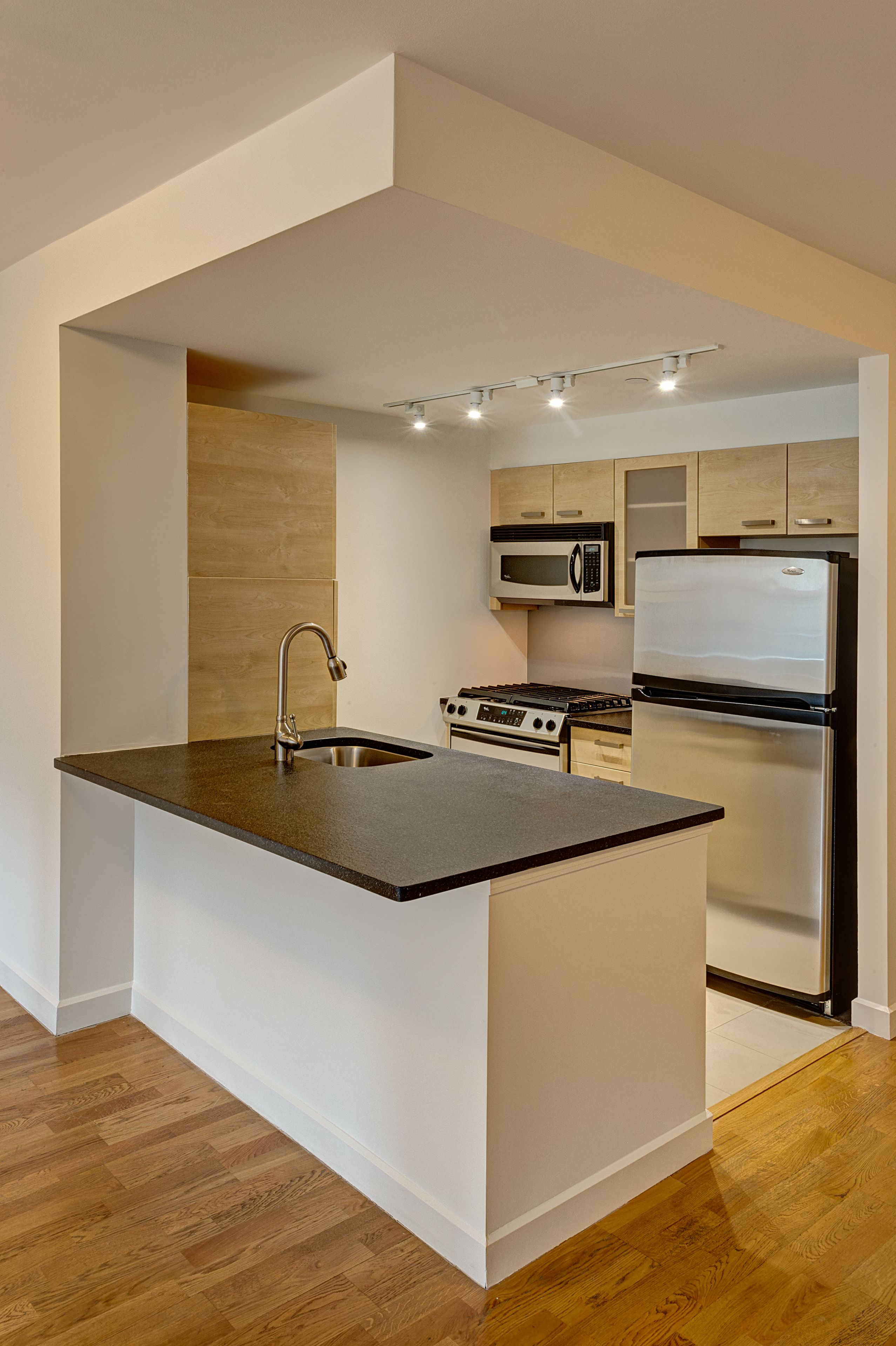 a kitchen with stainless steel appliances granite countertop a sink and a refrigerator