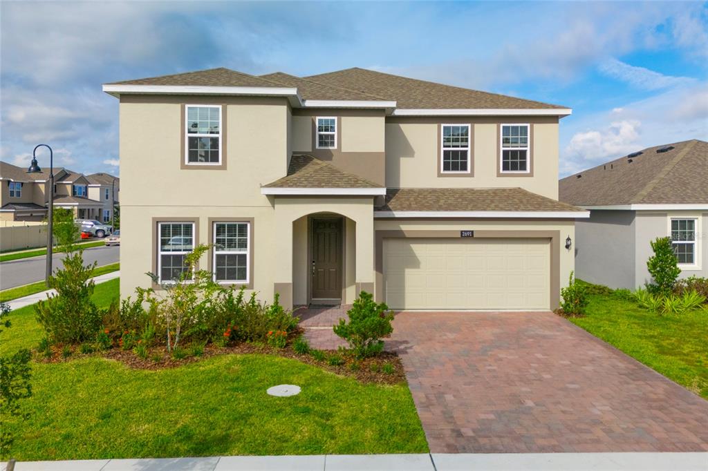 a front view of a house with a yard and garage