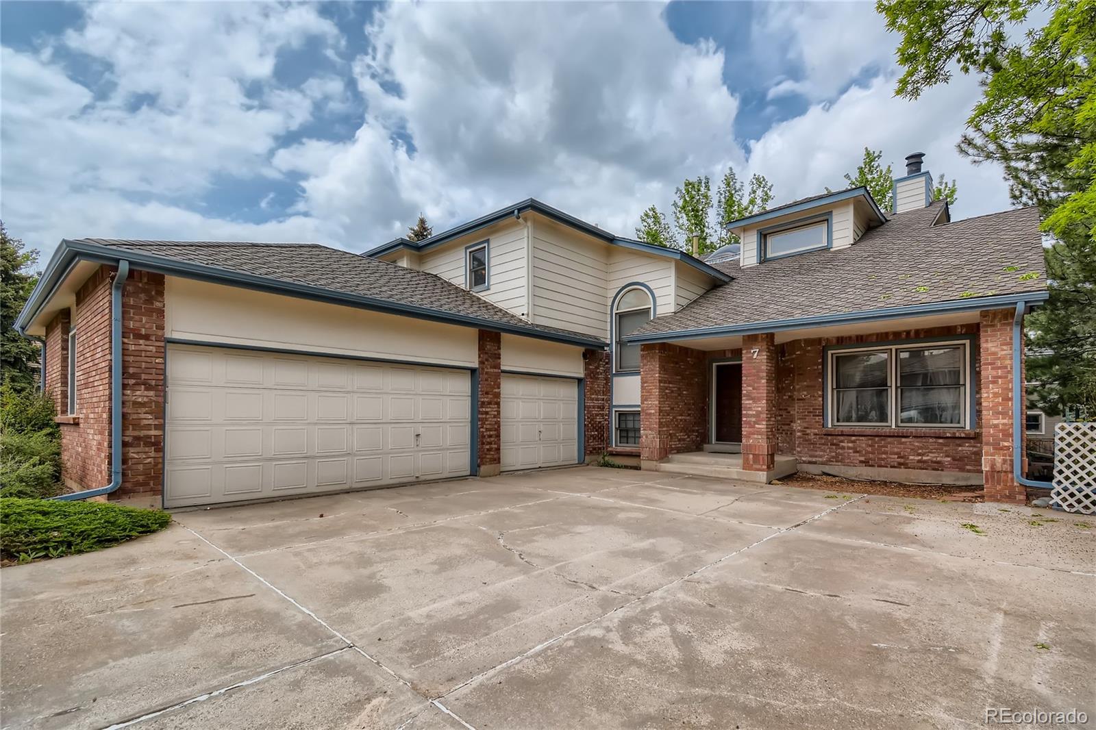 a view of a house with a garage and yard