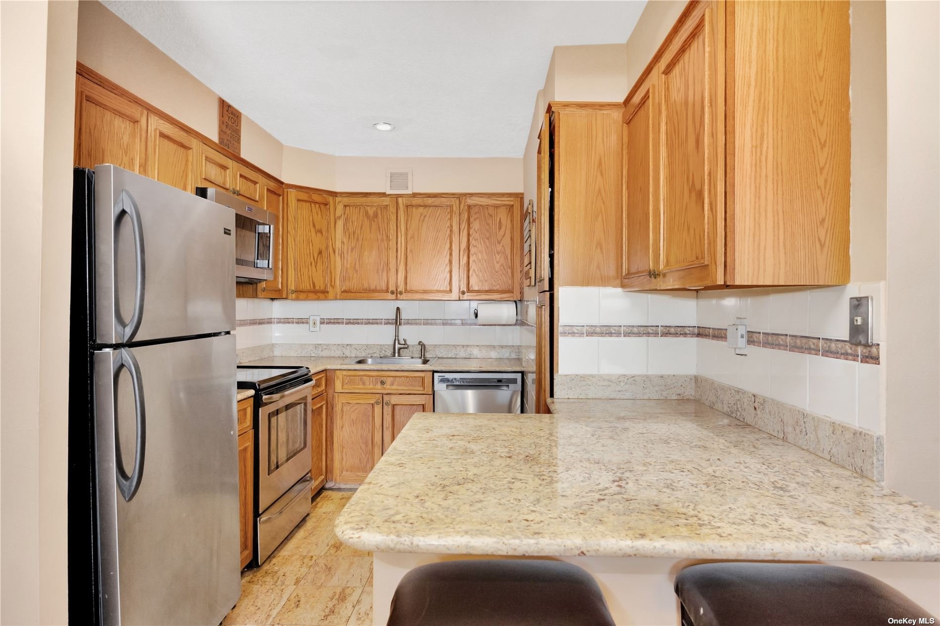 a kitchen with stainless steel appliances granite countertop a refrigerator a sink and a stove