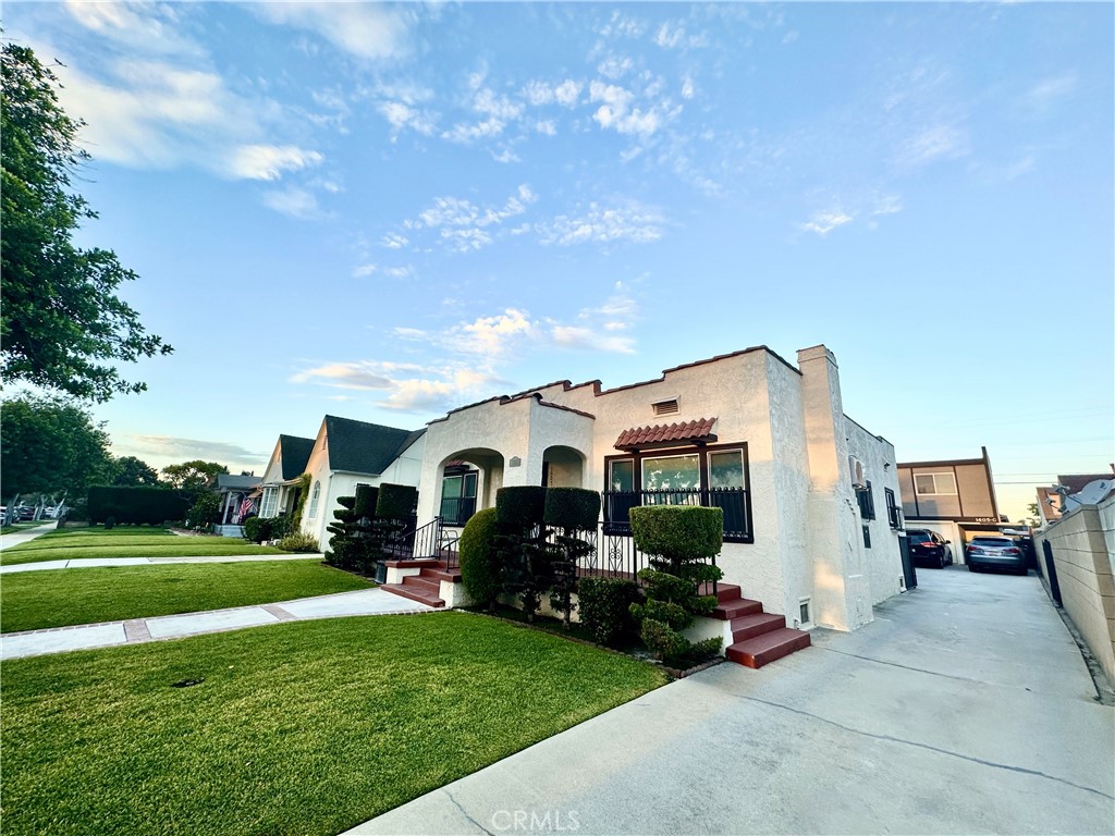 a front view of a house with a garden and yard