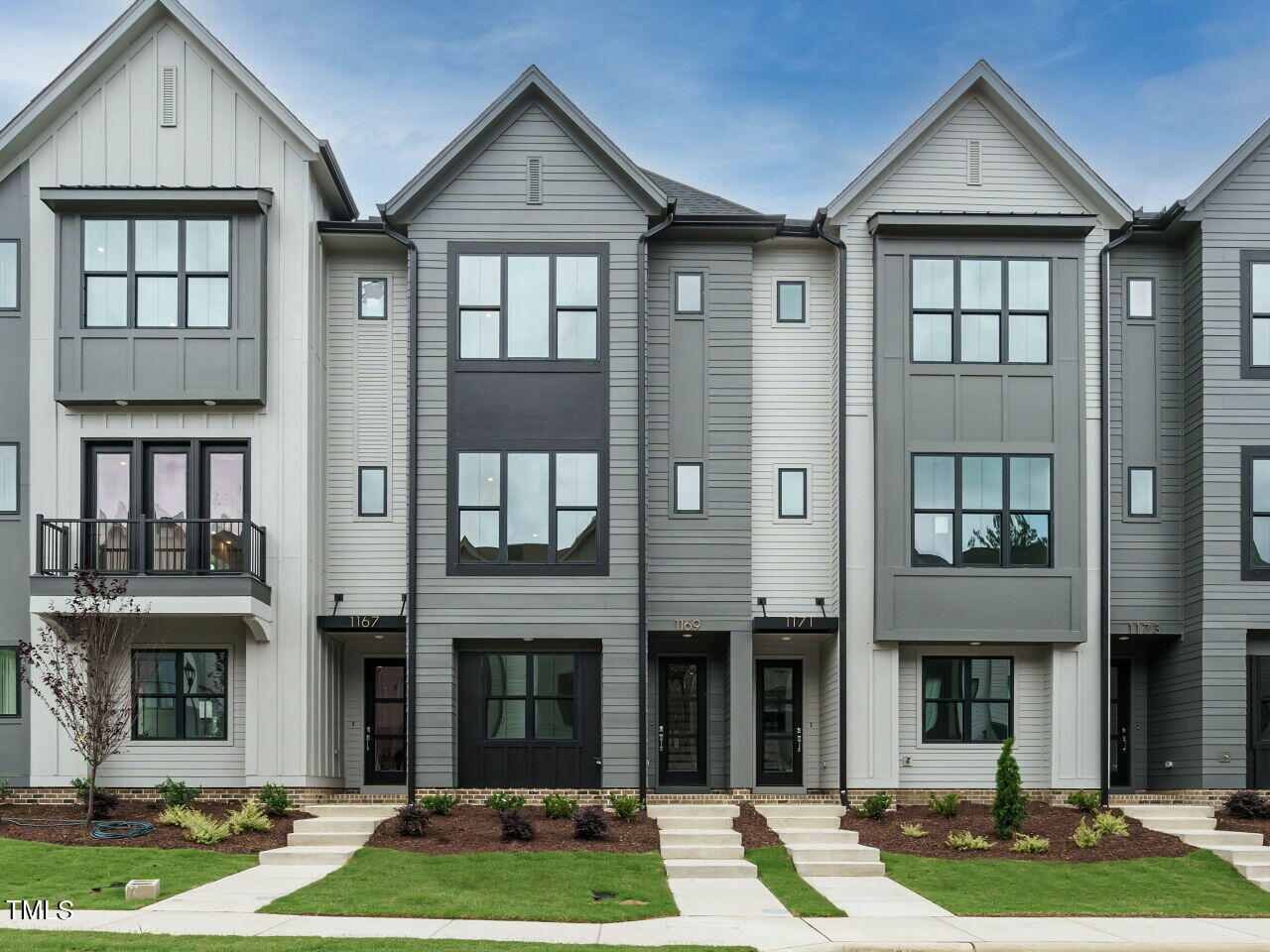 a front view of a residential apartment building with a yard