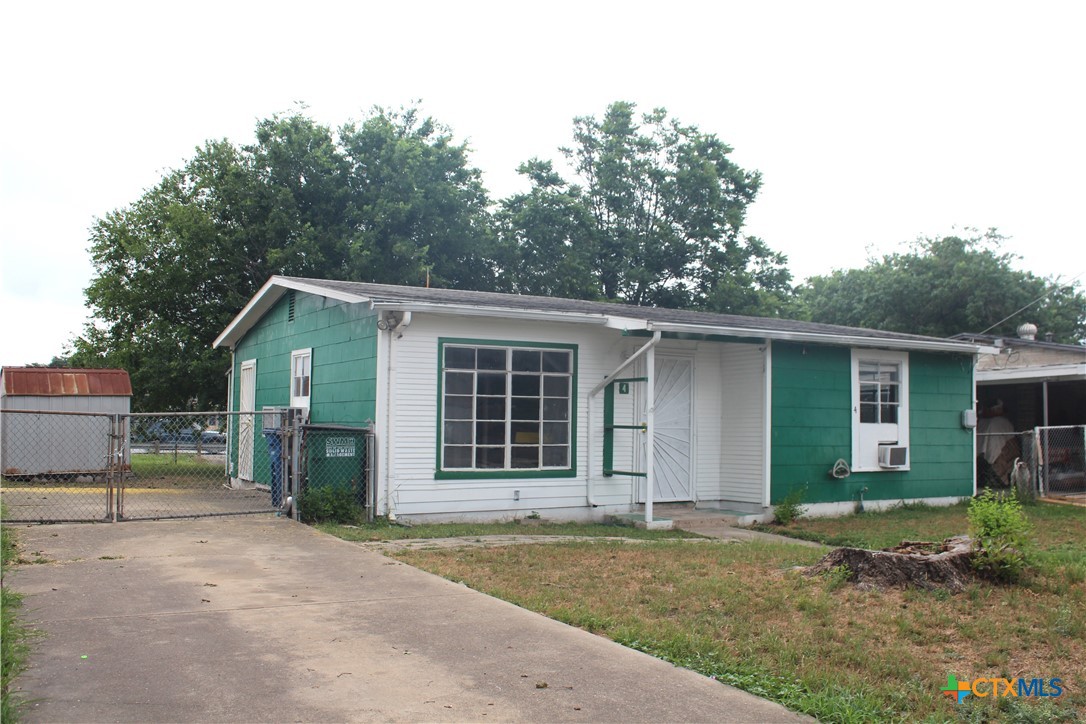 a view of a house with a yard and potted plants