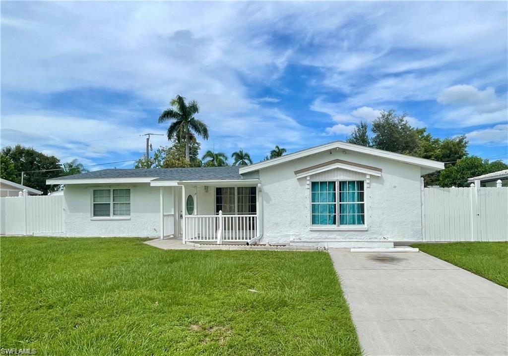 Single story home with covered porch and a front yard