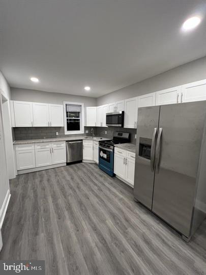 a kitchen with cabinets and wooden floor