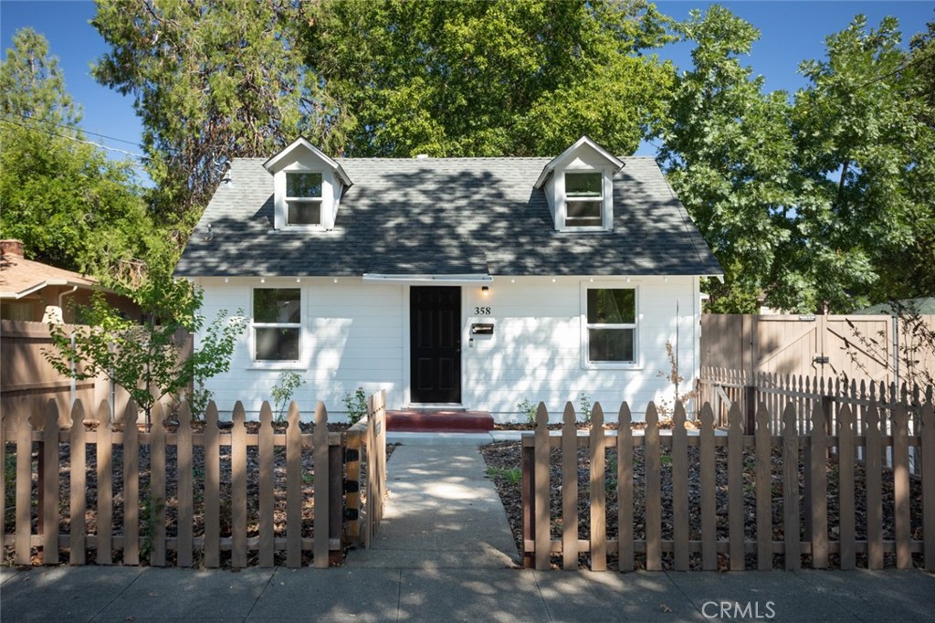 a front view of house with yard and trees in the background