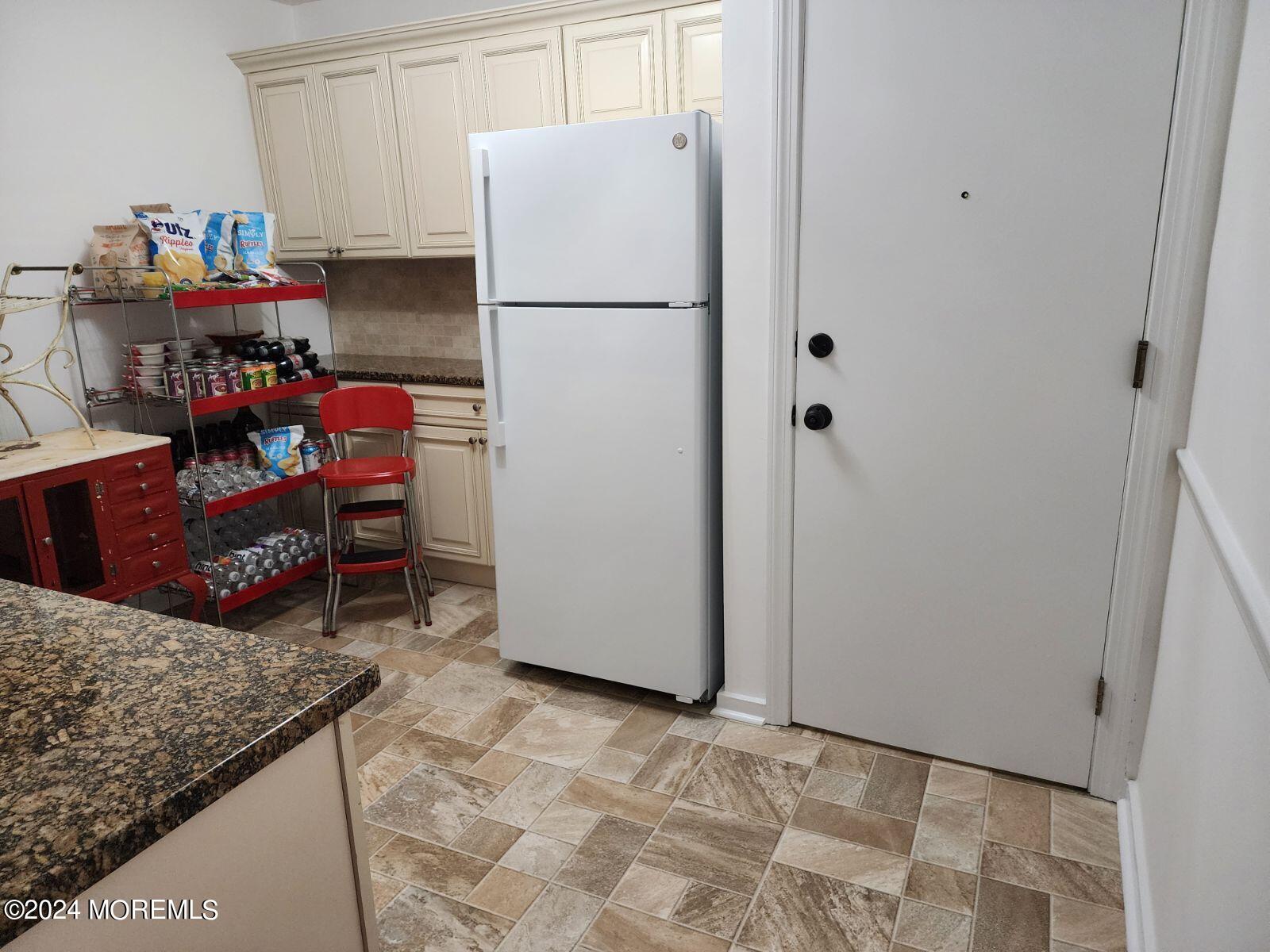 a kitchen with refrigerator and cabinets