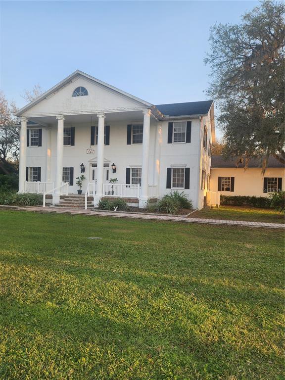 a front view of a house with a garden and trees