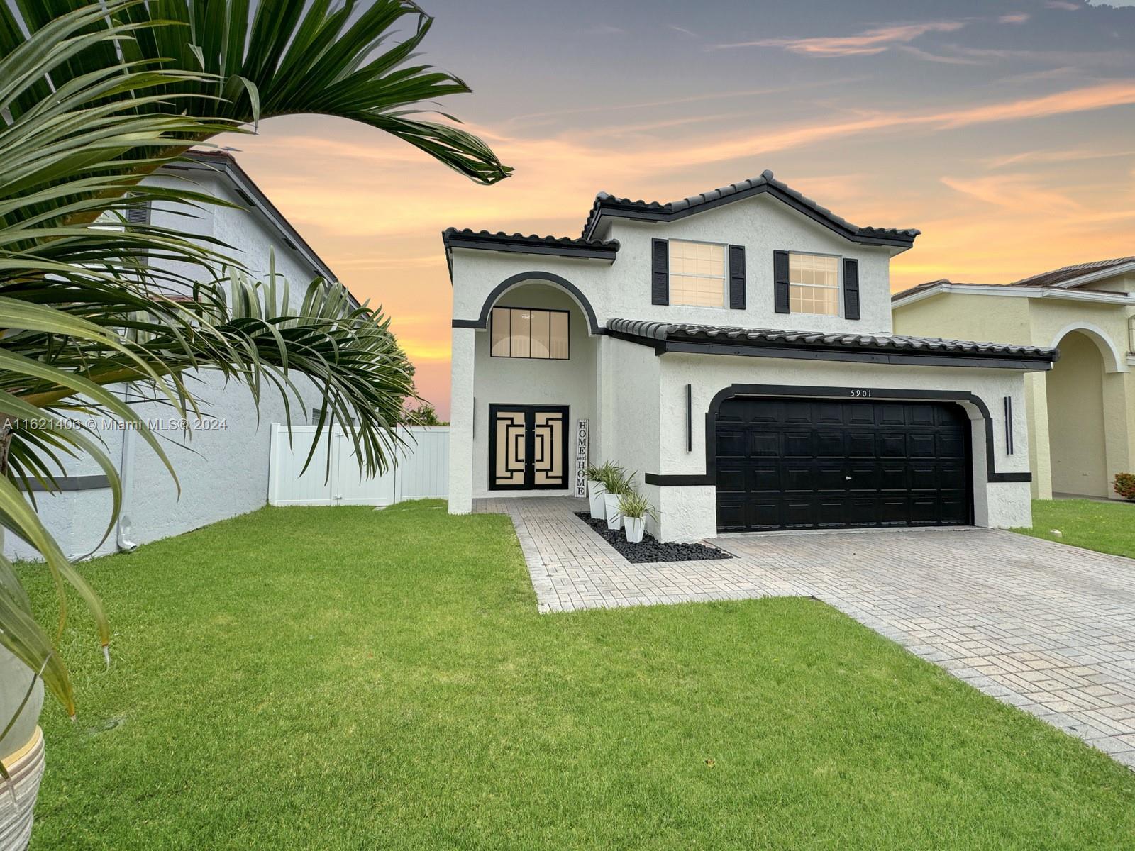 a front view of a house with yard and parking