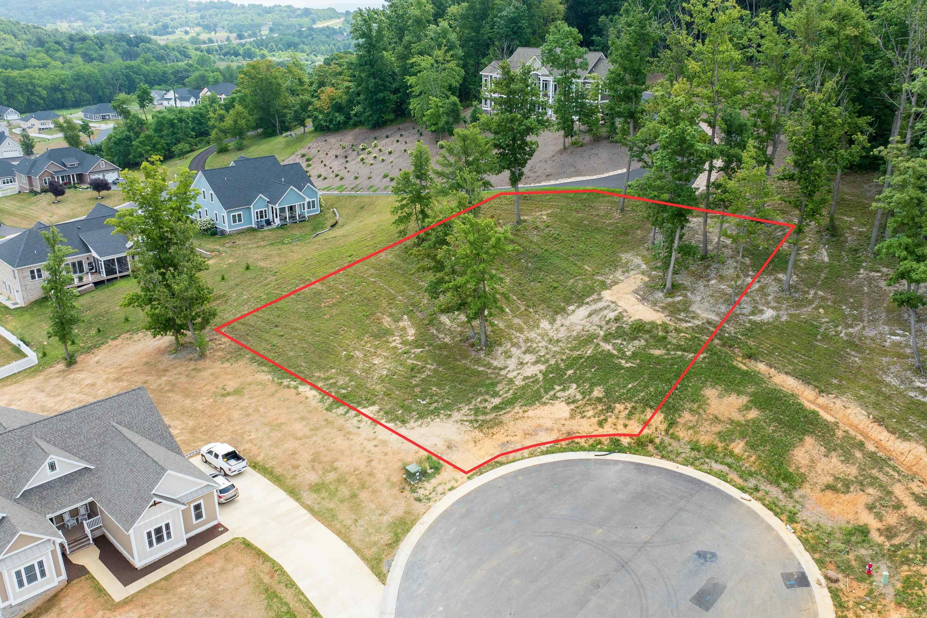 an aerial view of a house with a yard and trees all around