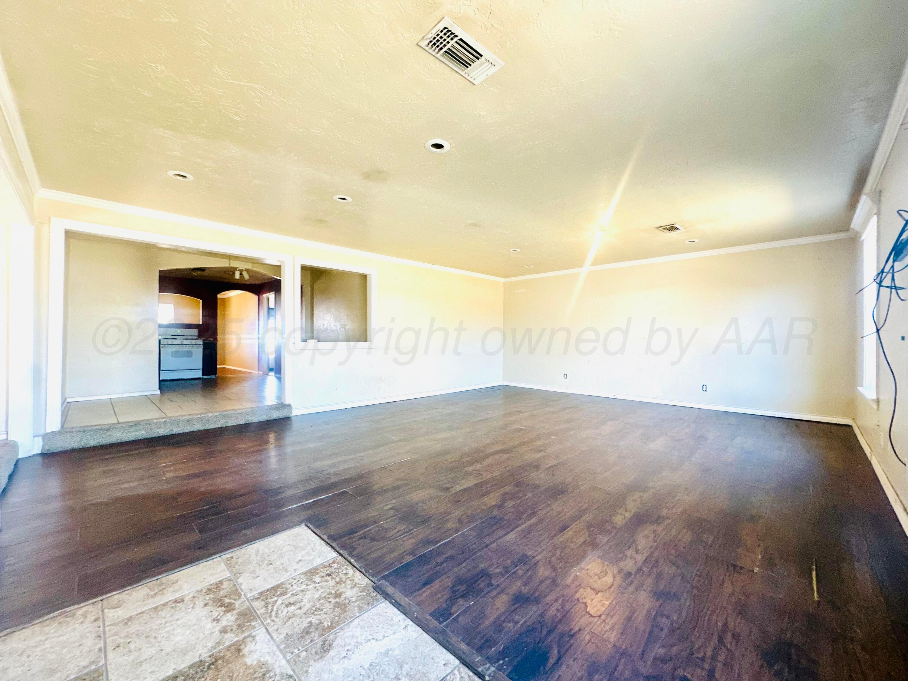 a view of empty room with wooden floor