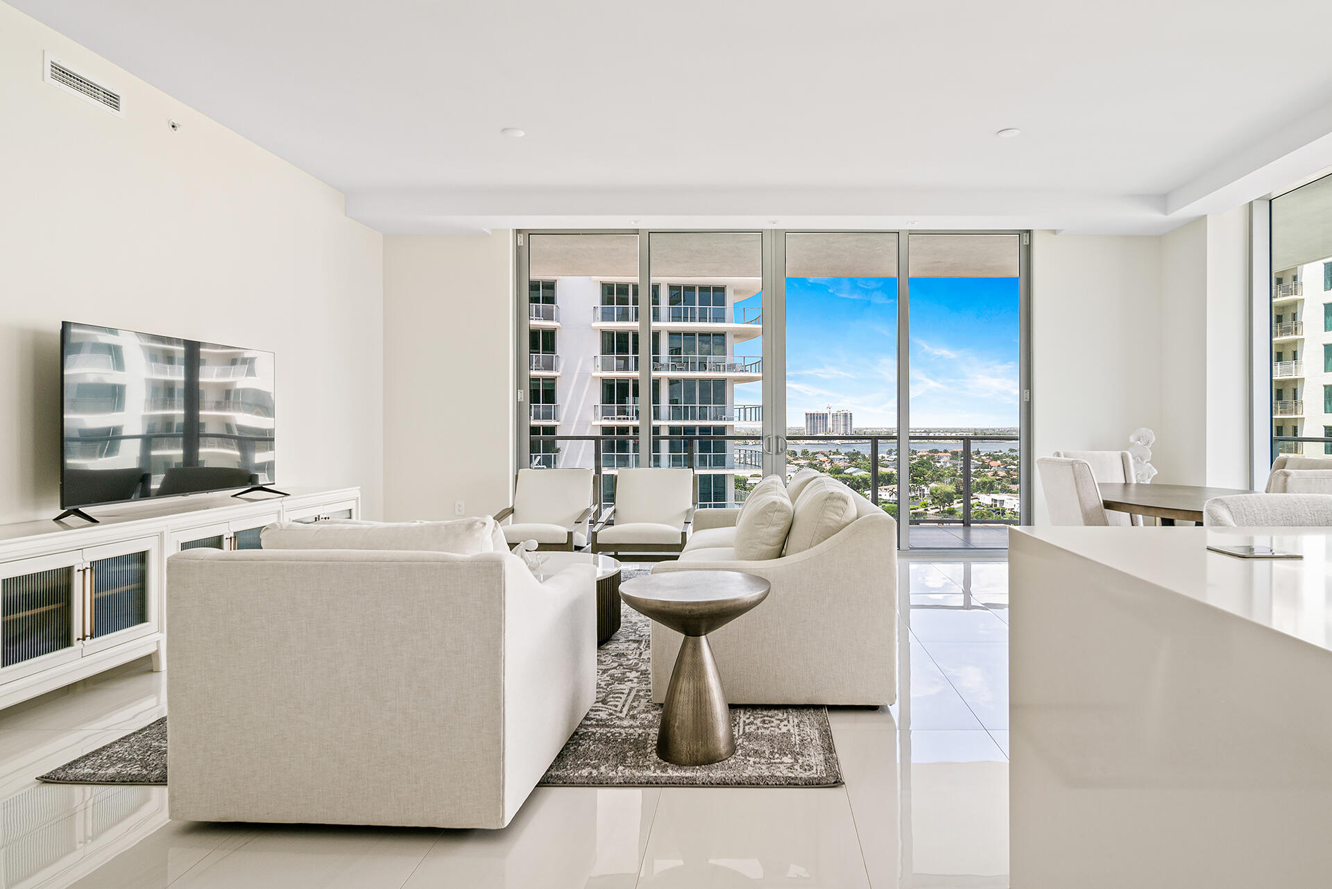 a living room with furniture a flat screen tv and a floor to ceiling window