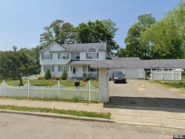 a view of a house with a yard and large tree