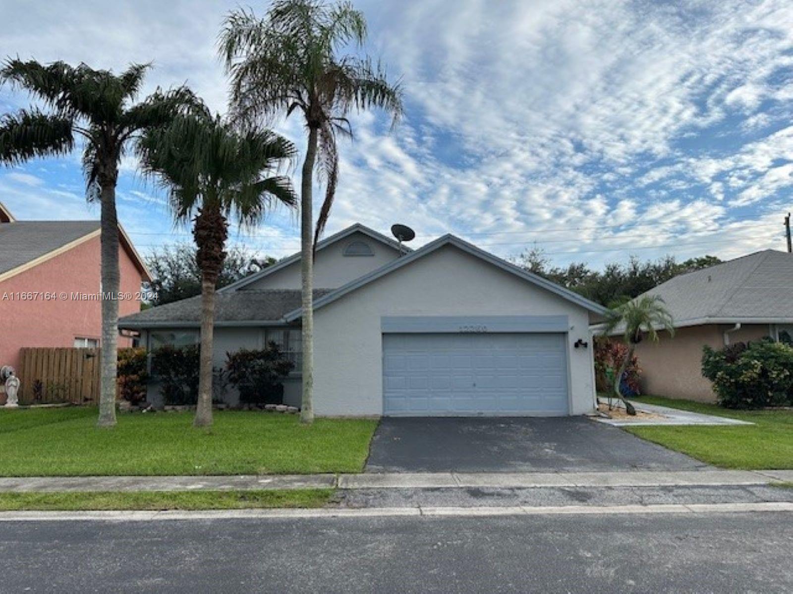 a view of a house with a yard and garage