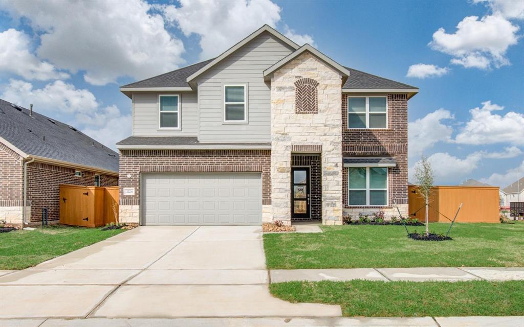 a front view of a house with a yard and a garage