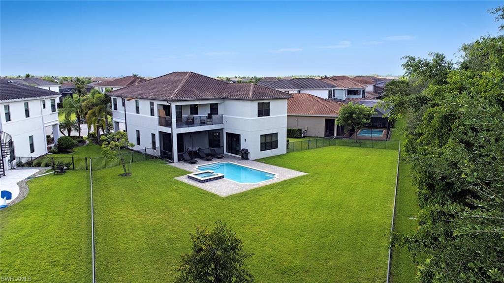 an aerial view of a house with swimming pool and a yard