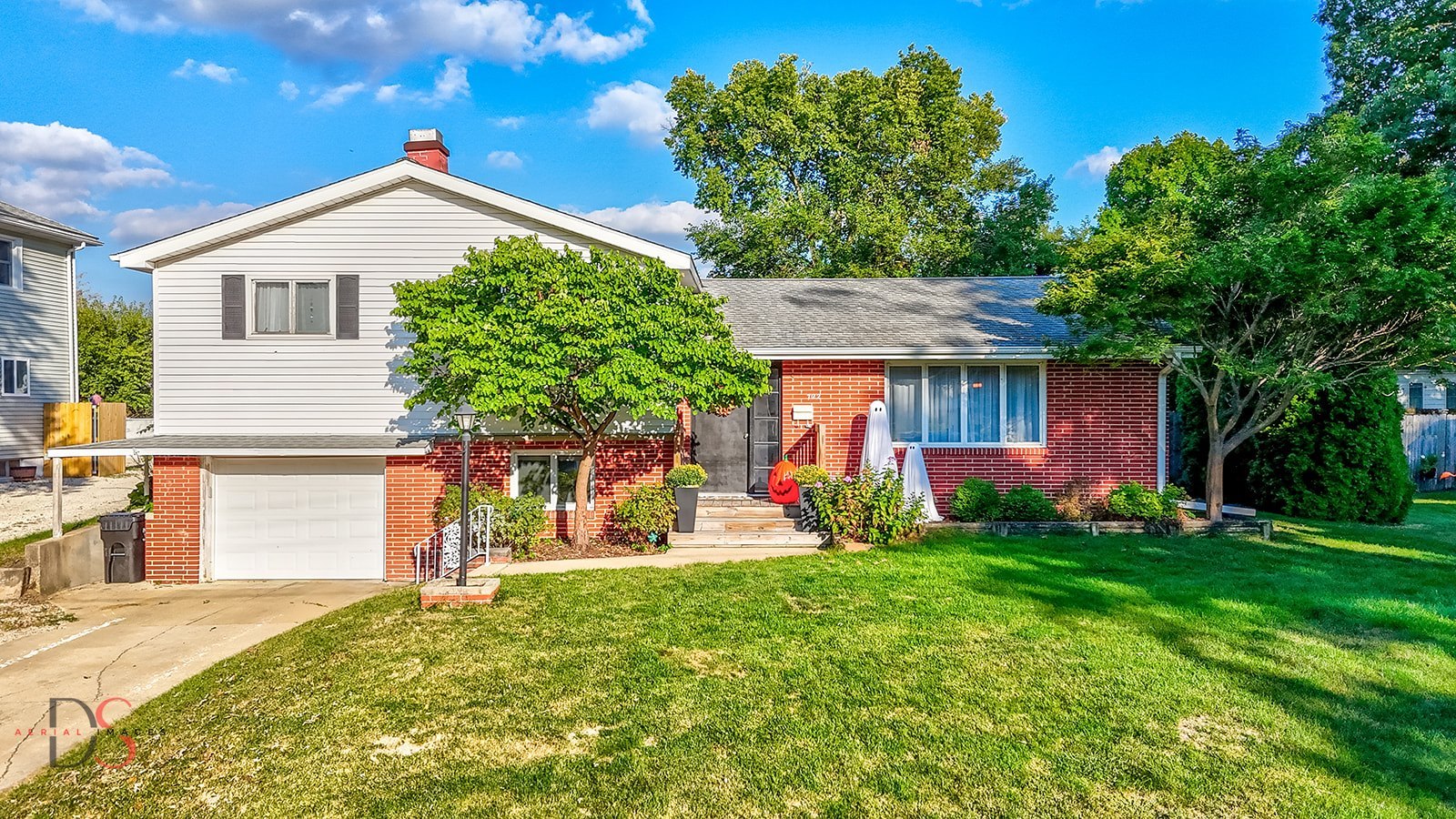 a front view of a house with a yard and trees