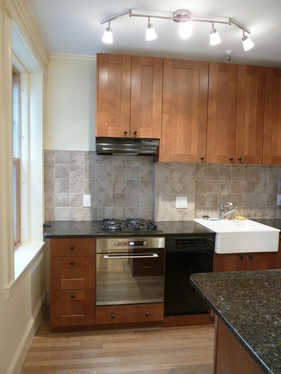 a kitchen with granite countertop a sink and cabinets