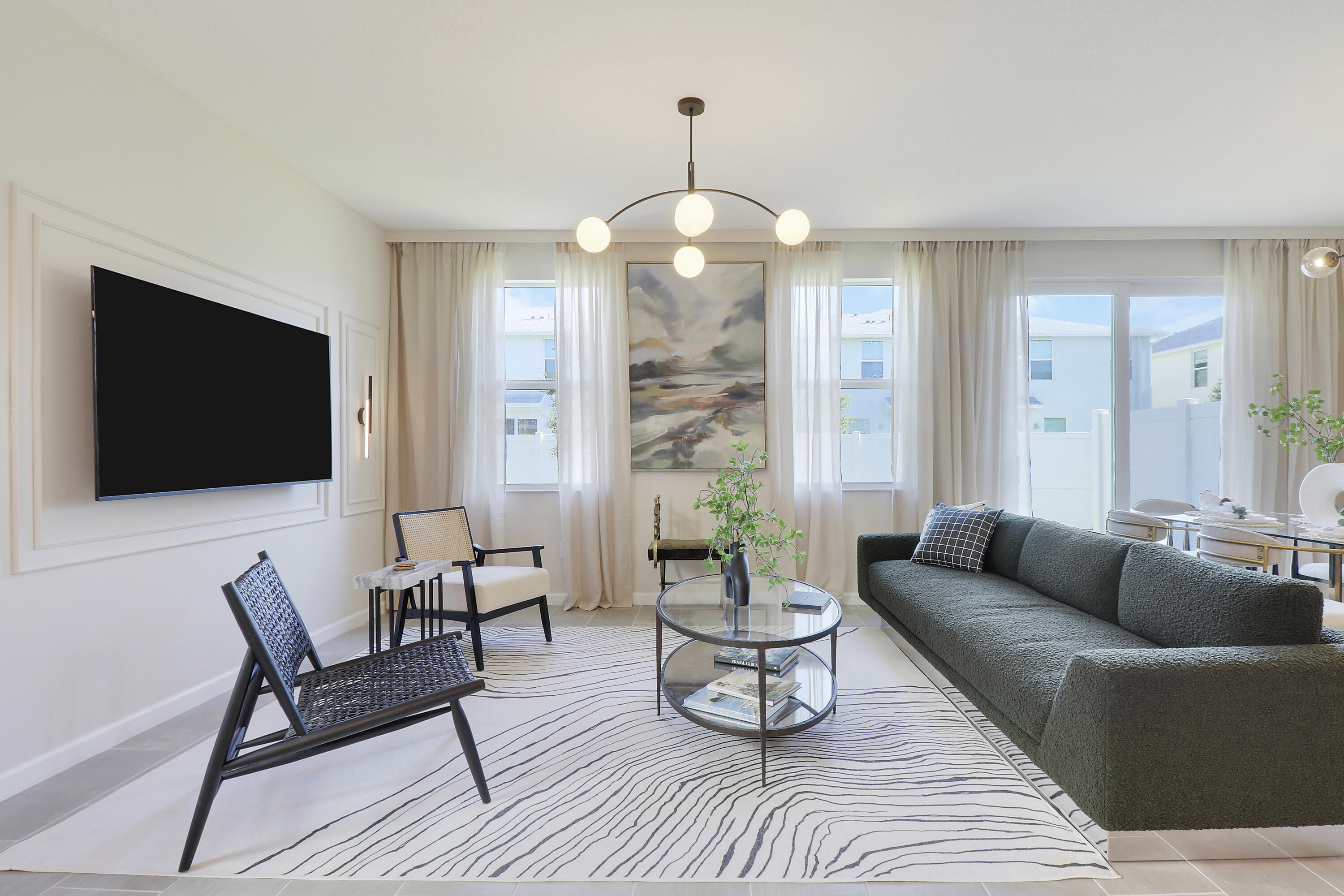 a living room with furniture a flat screen tv and a chandelier