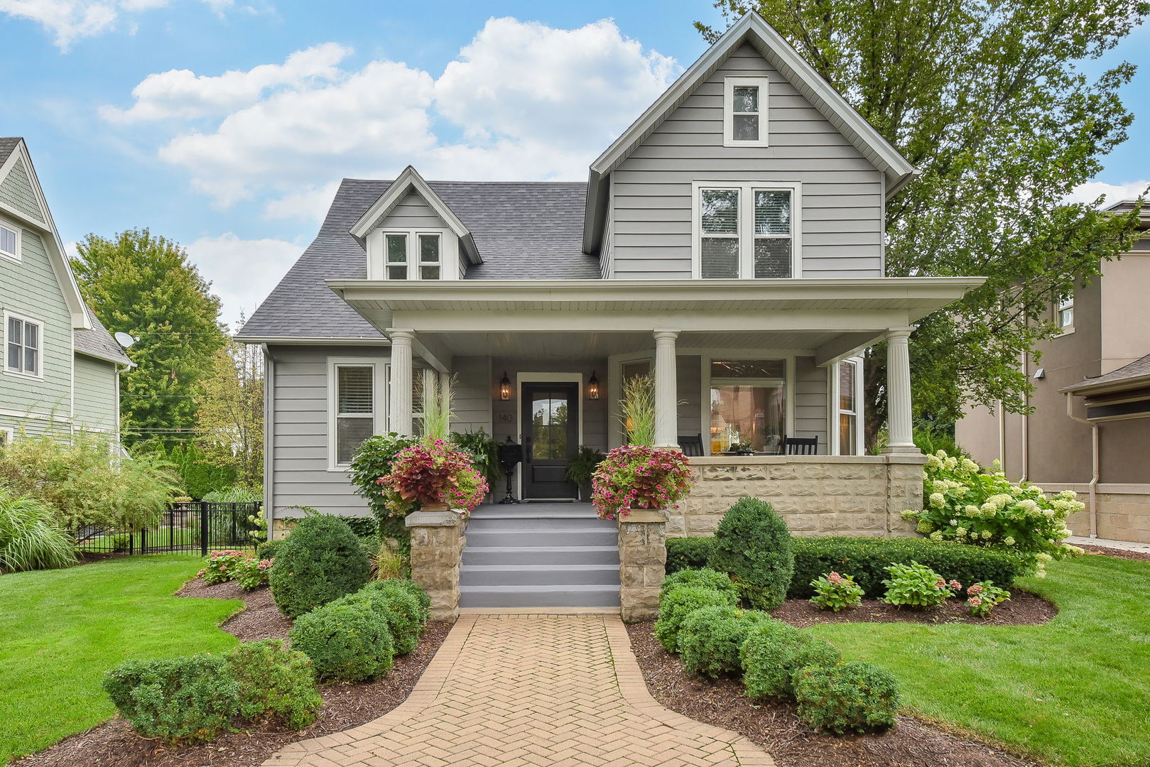 a front view of a house with yard and green space