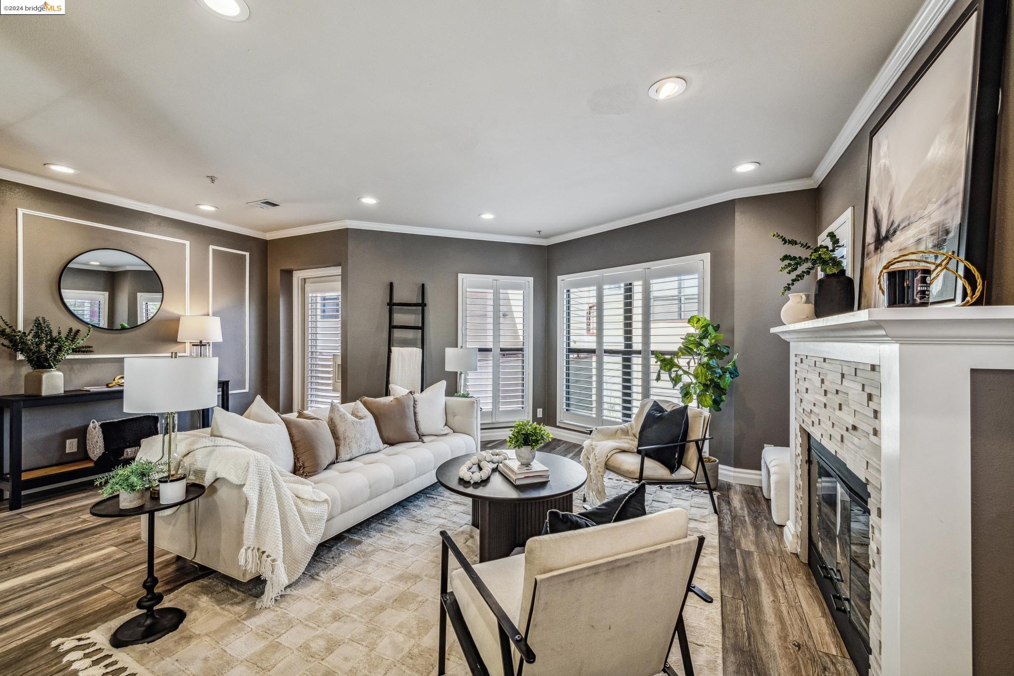 a living room with furniture a fireplace and a open kitchen view