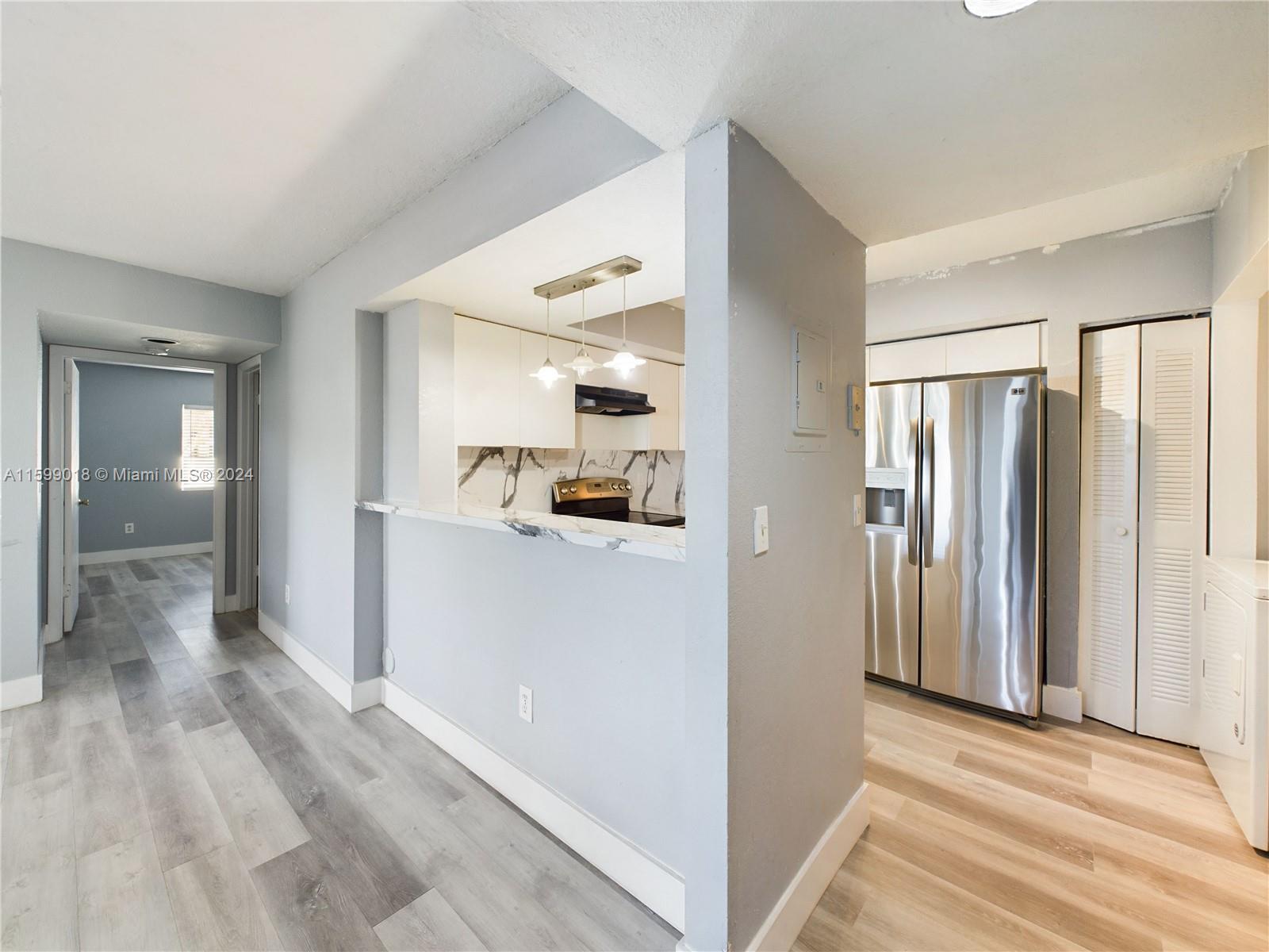 a view of a open shower and a kitchen