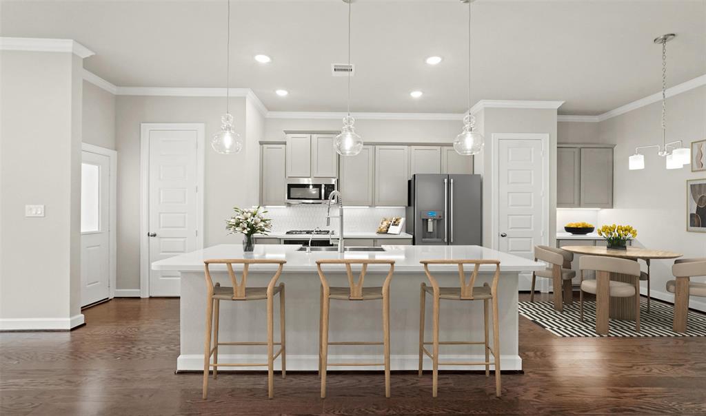 a kitchen with stainless steel appliances kitchen island granite countertop a table chairs stove and white cabinets